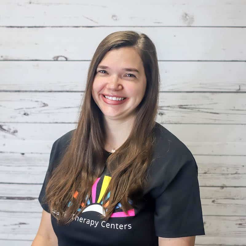 Aly_Rogers 2022 headshot photo with white wood background