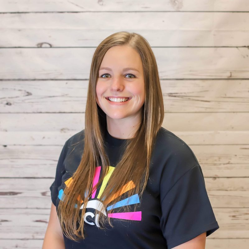 Cayla Carden headshot photo with white wood background.